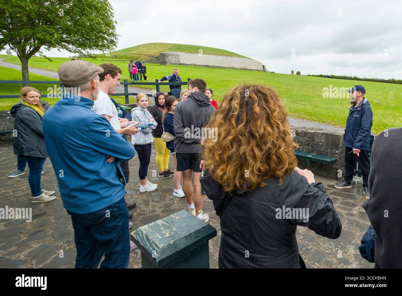Groupe de touristes écoutant la guilde locale parler de Newgrange tumulus, Brú na Bóinne, Stalleen, County Meath, Irlande Banque D'Images
