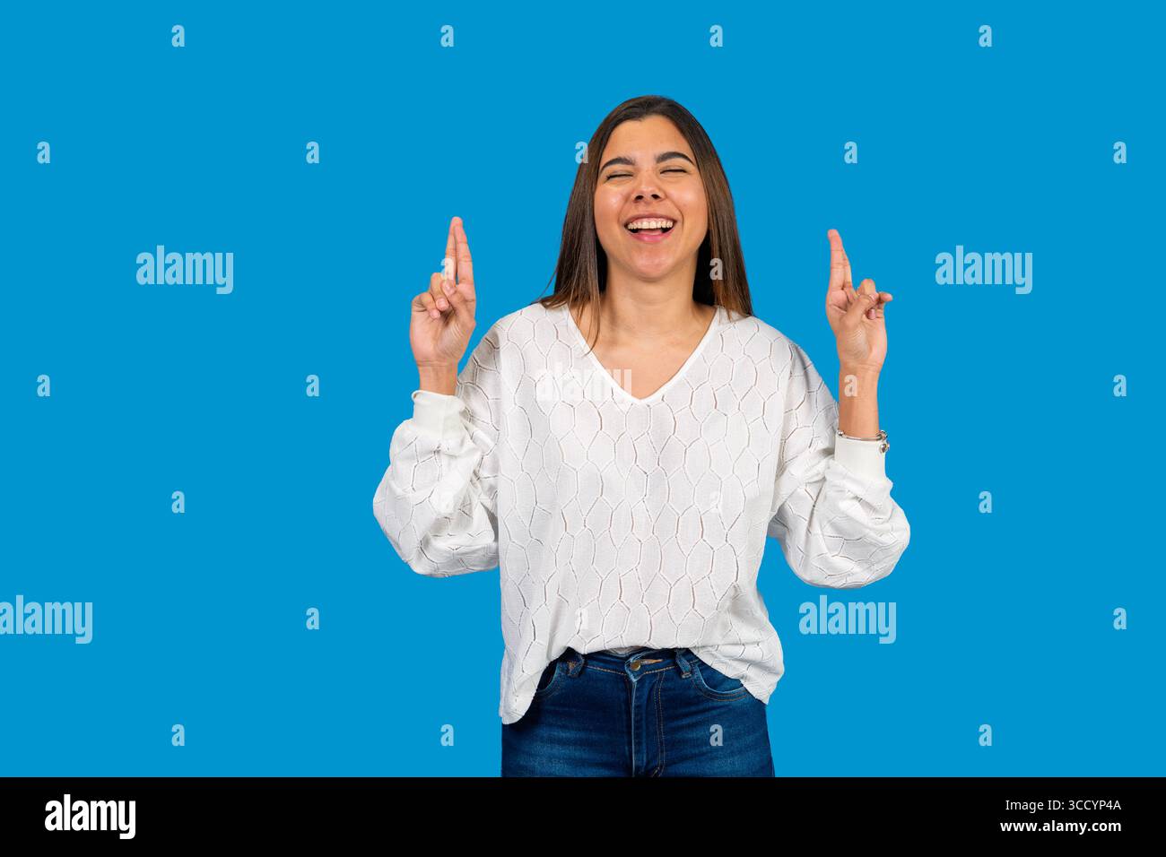 Femme excitée avec les doigts croisés fait un vœu, espérant bonne chance et résultat positif Banque D'Images