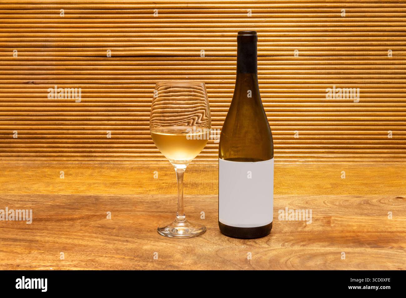Composition minimaliste d'une bouteille de vin à moitié pleine et d'un verre finement sculpté Banque D'Images