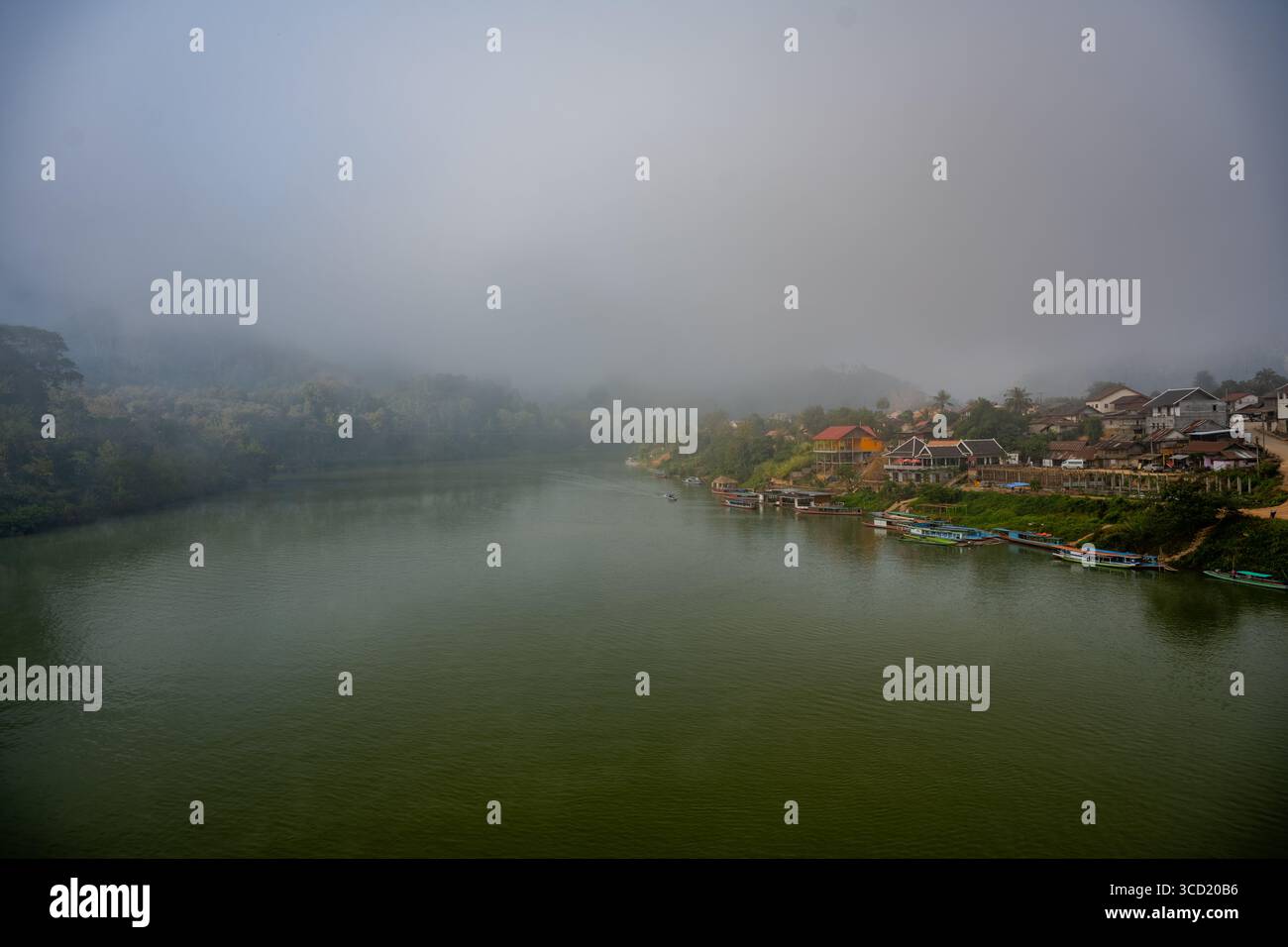 Matinée brumeuse sur Riverside Village et bateaux le long de la rivière Nam ou dans le district de Ngoy, au nord du Laos Banque D'Images