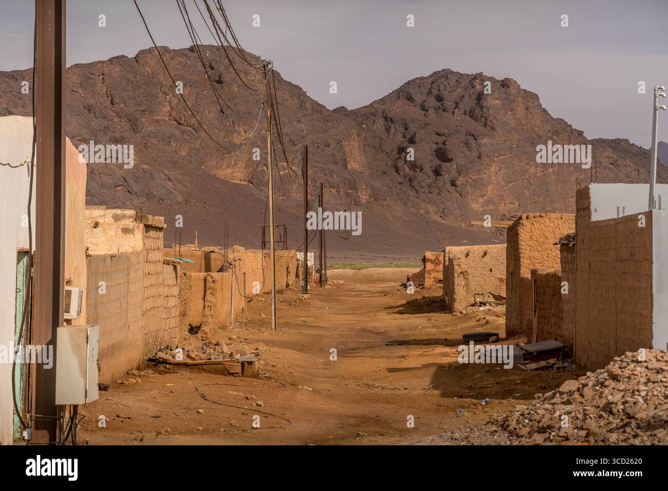 Fderik, Mauritanie : ville du Sahara sous une colline de déblai de charbon ; maisons en briques de boue, rues clairsemées et difficultés sociales dans le Sahel. Banque D'Images