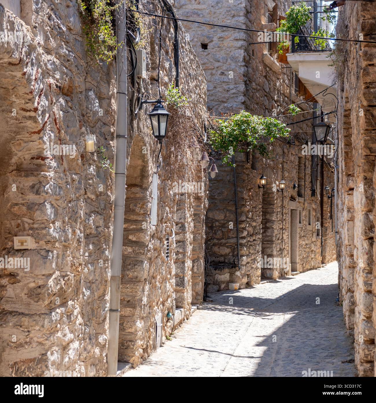 Village médiéval de Mesta. Île de Chios, Grèce. Ruelle pavée étroite, architecture traditionnelle maisons en pierre et arche. Portes en bois rustiques et lanterne Banque D'Images