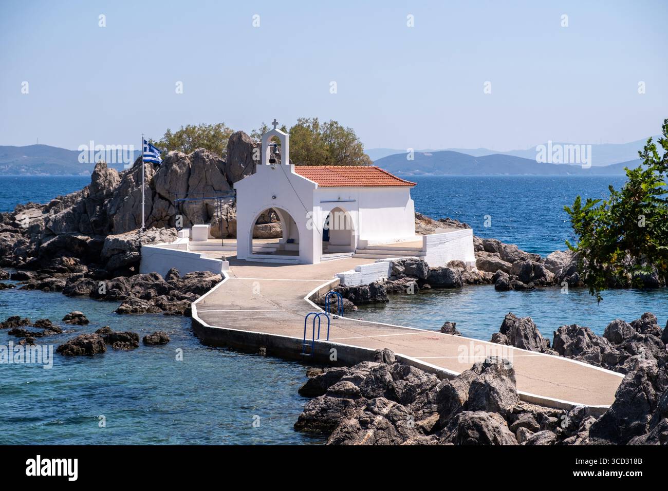 Chios, petite église d'Agios Isidoros, Grèce. Chapelle d'architecture traditionnelle avec toit de tuiles rouges et clocher sur les rochers, journée d'été ensoleillée Banque D'Images