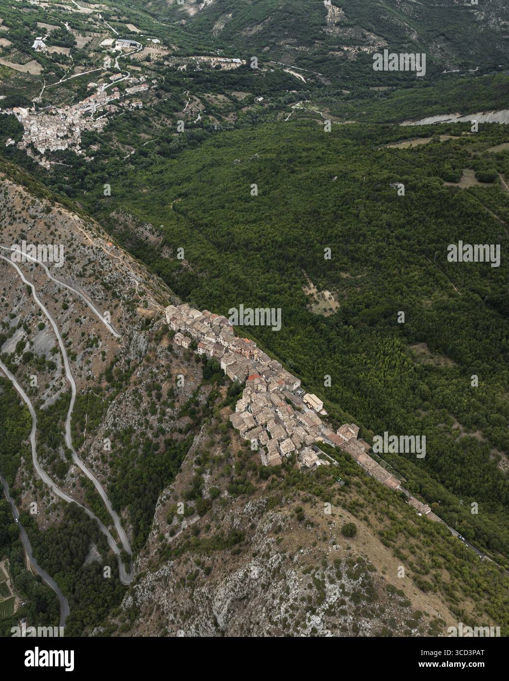 Vue aérienne de l'ancien village accroché à la crête de la montagne, entouré de forêts verdoyantes et de routes sinueuses, Castrovalva, Abruzzes, Italie. Banque D'Images