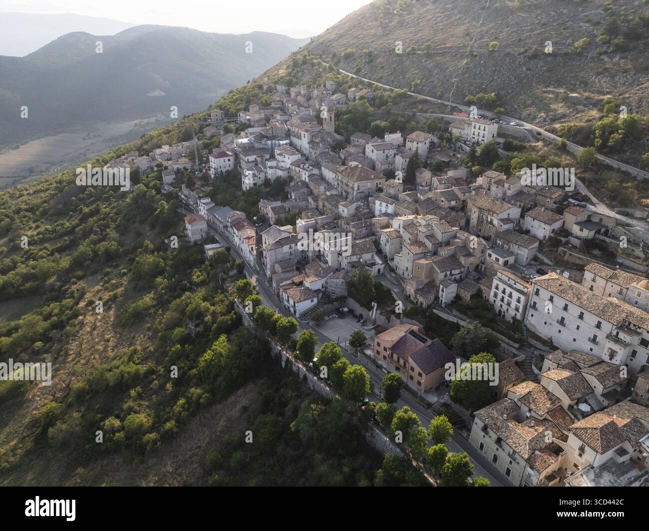 Vue aérienne de l'ancien village accroché à la montagne, ses bâtiments en pierre et ses toits en terre cuite se mélangeant parfaitement avec le paysage accidenté, Rocca Calascio, Abruzzes, Italie. Banque D'Images