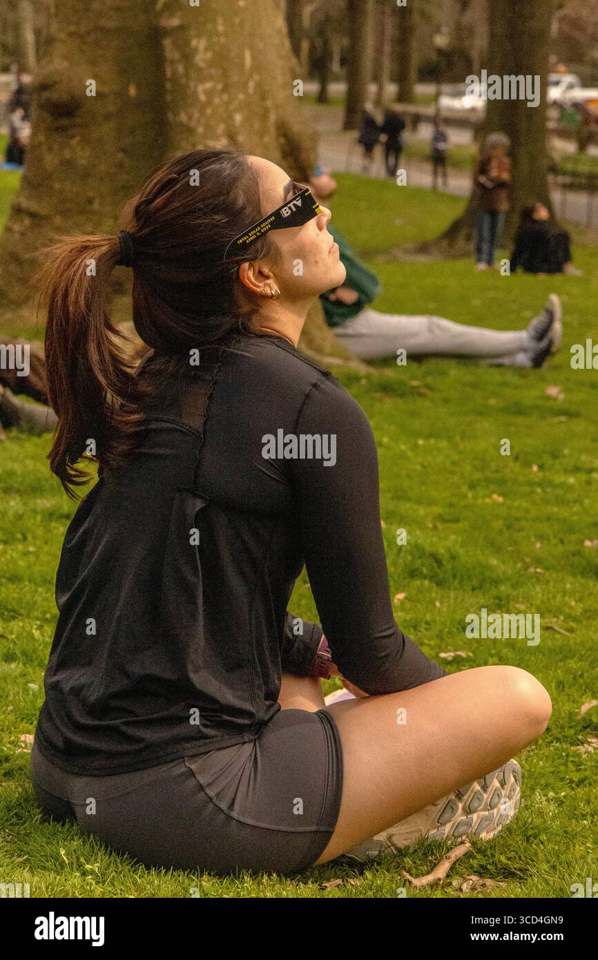 Vue en bas angle de personnes observant l'éclipse solaire d'avril 2024 à Central Park, Manhattan, New York, États-Unis, capturant la vie urbaine et extérieure Banque D'Images