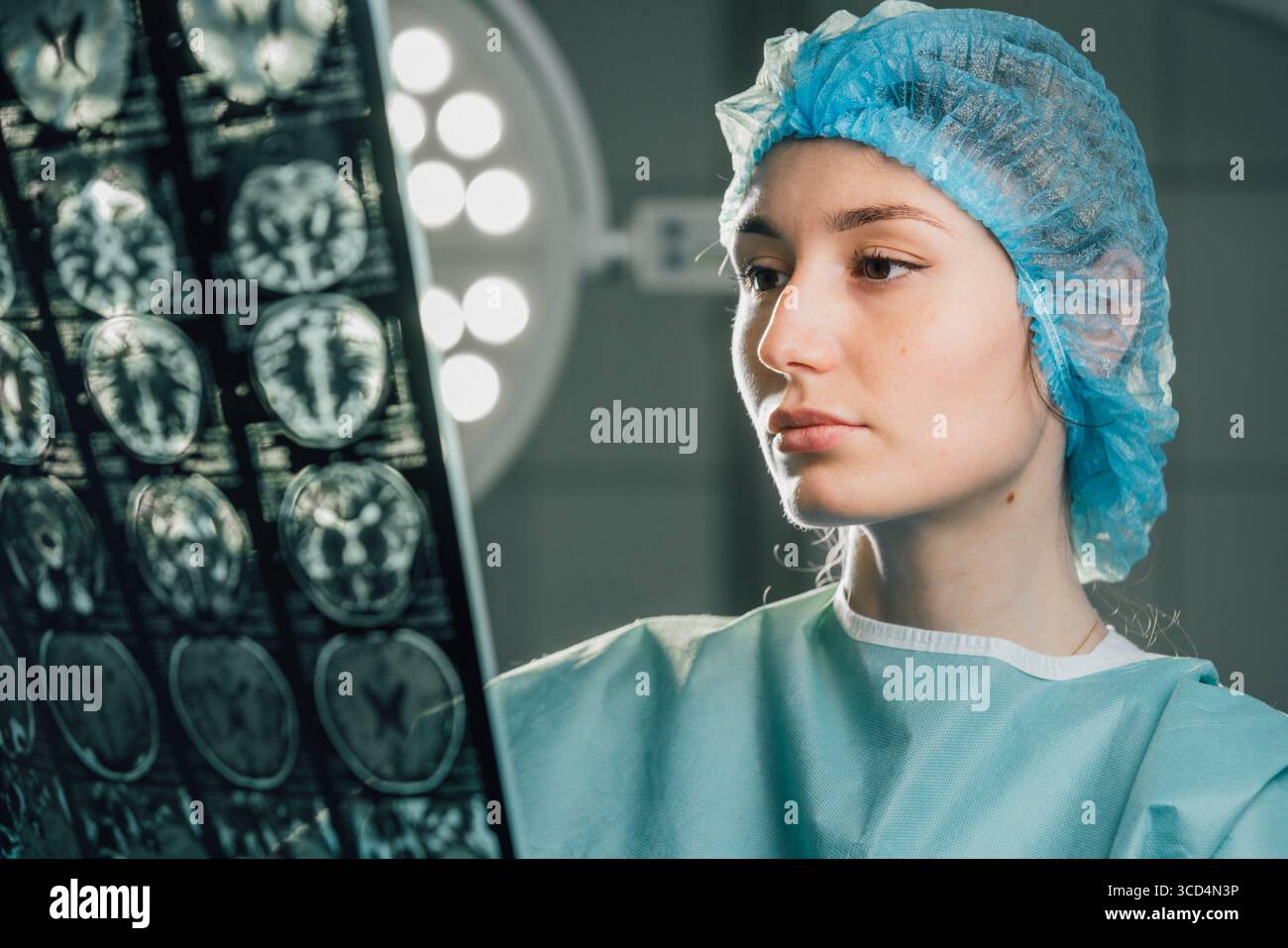 Chirurgien féminin en salle d'opération, axé sur l'analyse des images de scintigraphie cérébrale sous des lumières chirurgicales vives, démontrant son engagement envers les soins de santé et les préc Banque D'Images