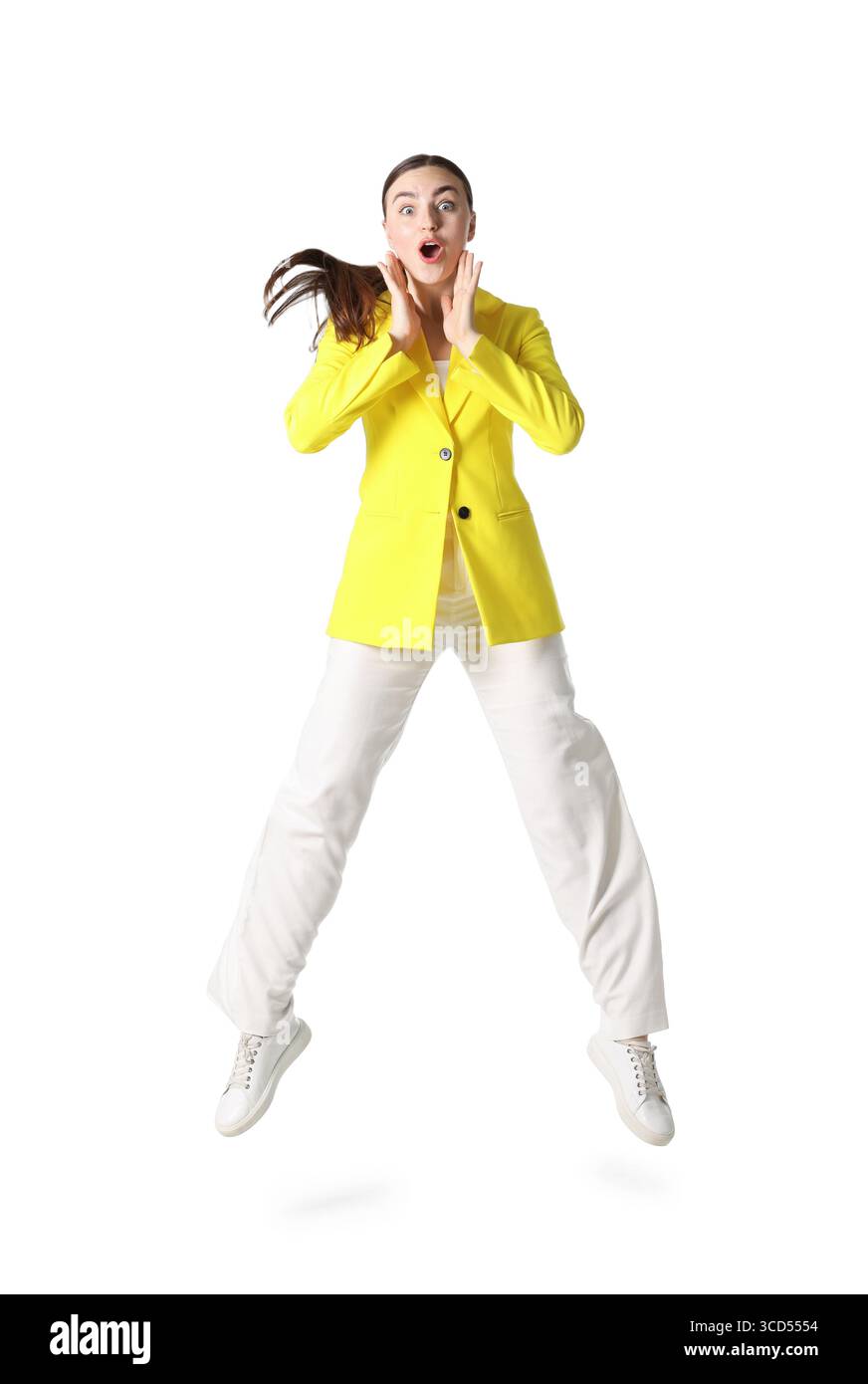 Femme en veste jaune sautant sur fond blanc Banque D'Images