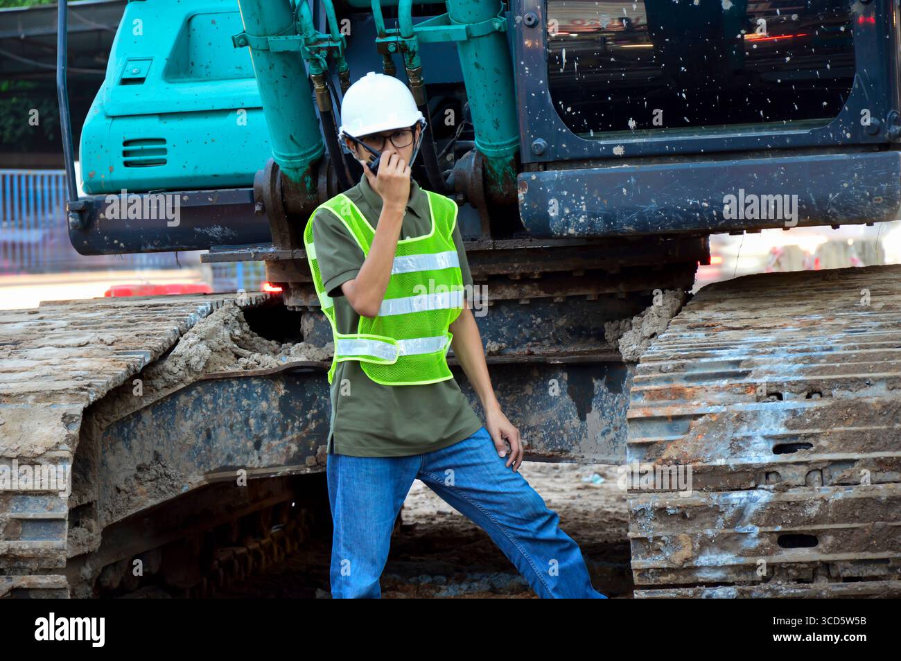 Un ingénieur masculin utilise une radio pour donner des ordres. Banque D'Images