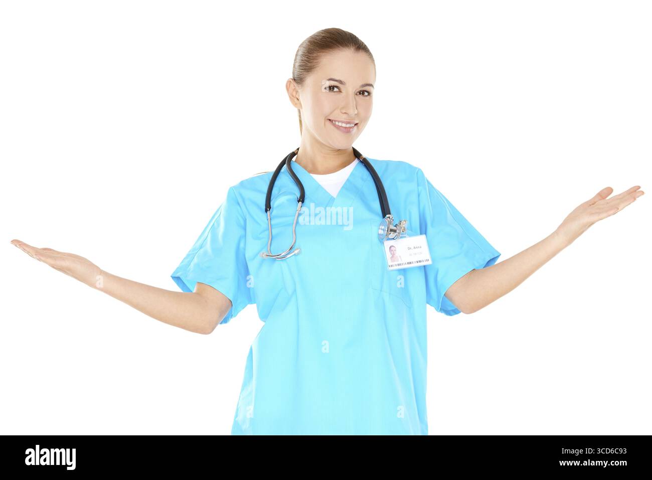 Femme souriante médecin dans des gommages verts debout levant ses mains sur les côtés pour indiquer et inclure son environnement isolé sur blanc Banque D'Images