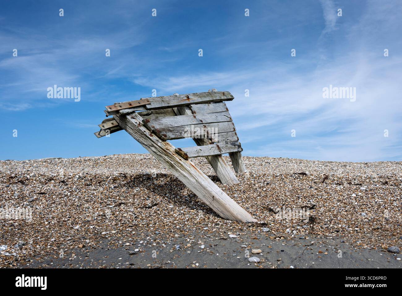 Structure rustique en bois inclinée au milieu d'une plage couverte de galets Banque D'Images
