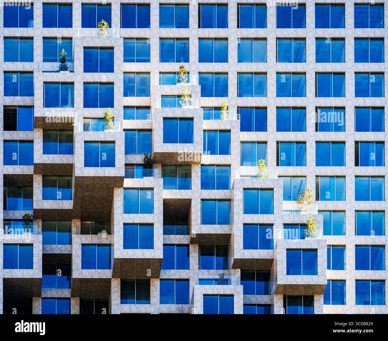 Façade de bâtiment moderne avec balcons cubiques saillants et fenêtres teintées de bleu. Banque D'Images