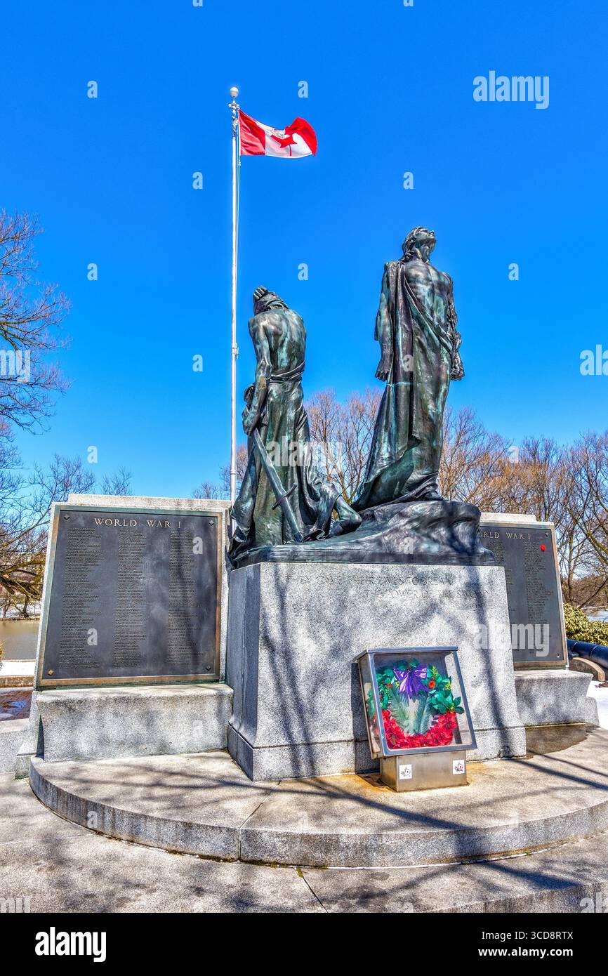 Drapeau canadien flottant au-dessus du monument commémoratif du Perth Regiment dans les Cenotaph Memorial Gardens - Stratford, Ontario, Canada. Banque D'Images