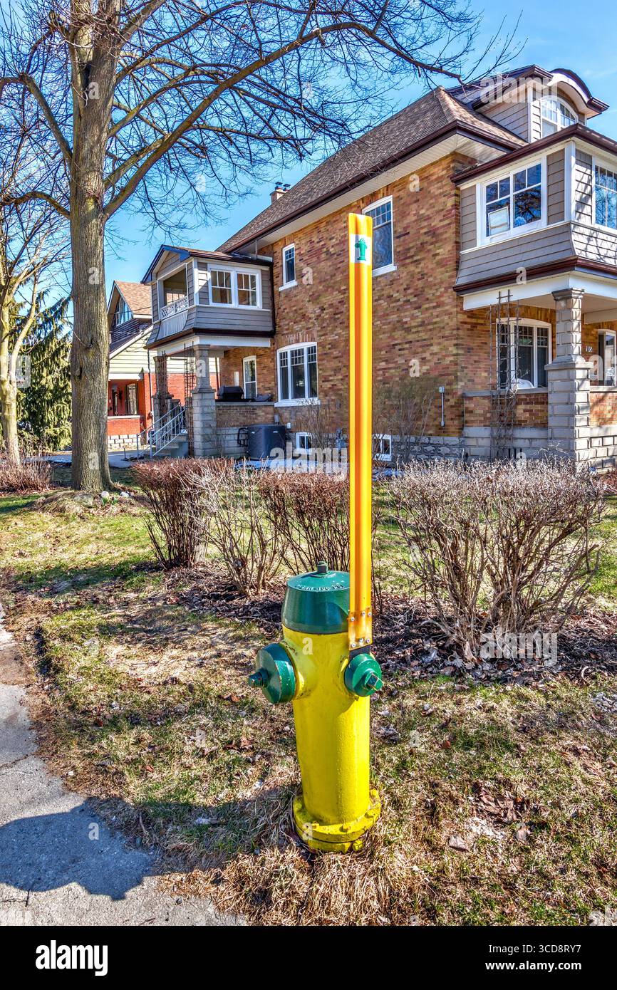 Poteau jaune de 2 mètres de haut placé pour localiser une bouche d'incendie après une forte chute de neige en hiver - Stratford, Ontario, Canada. Banque D'Images
