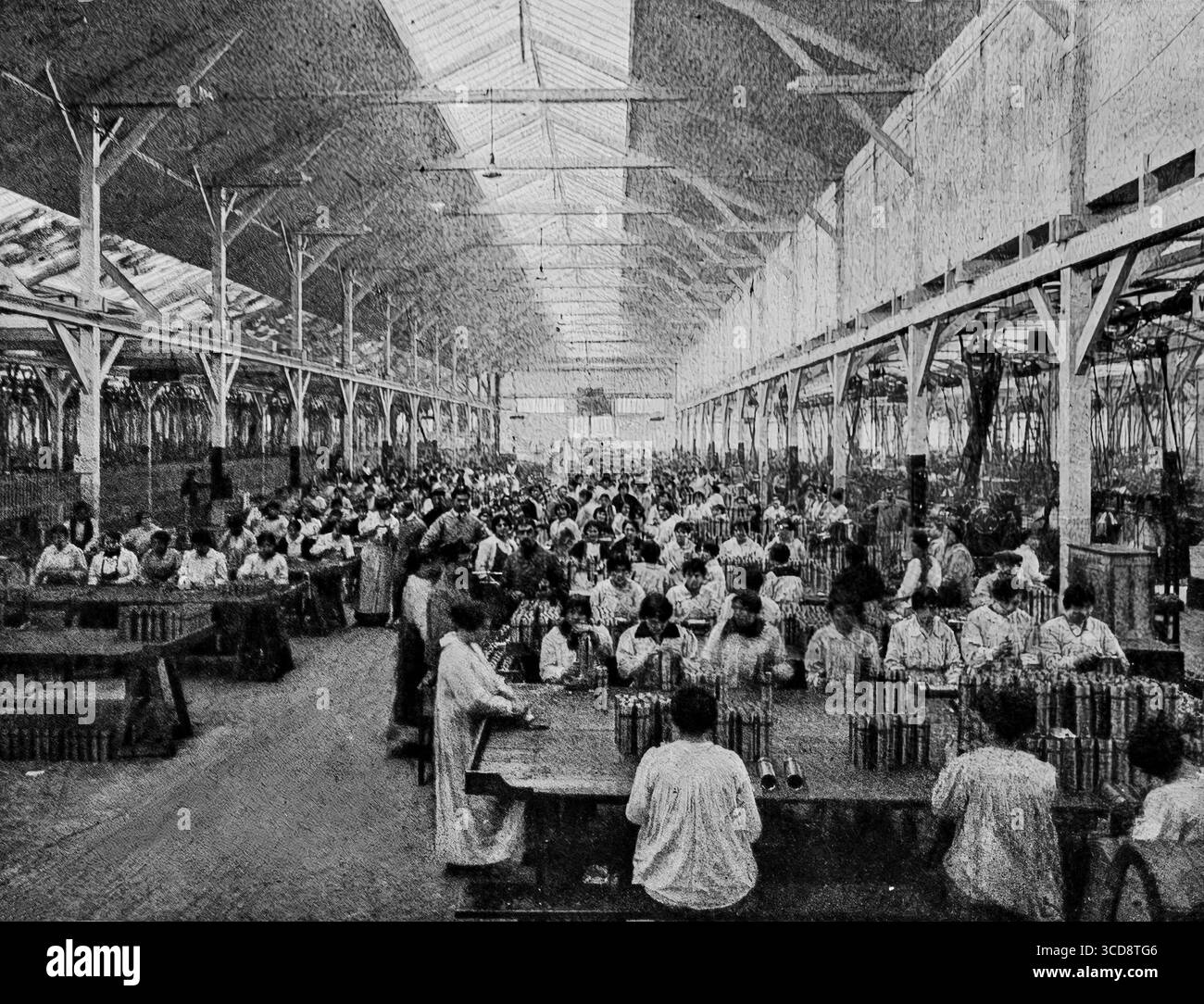 Avril 1916 L’illustration photographie de femmes dans un atelier d’usine de guerre française inspectant des obus d’artillerie pendant la première Guerre mondiale prise dans les ateliers André Citroën pour l’album du ministère français des munitions, l’image montre des rangées de travailleuses assises à de longues tables, examinant des obus pour le contrôle de la qualité. Cette scène reflète la mobilisation industrielle massive et le rôle vital des femmes dans le maintien de l'effort de guerre allié sur le front intérieur. Banque D'Images
