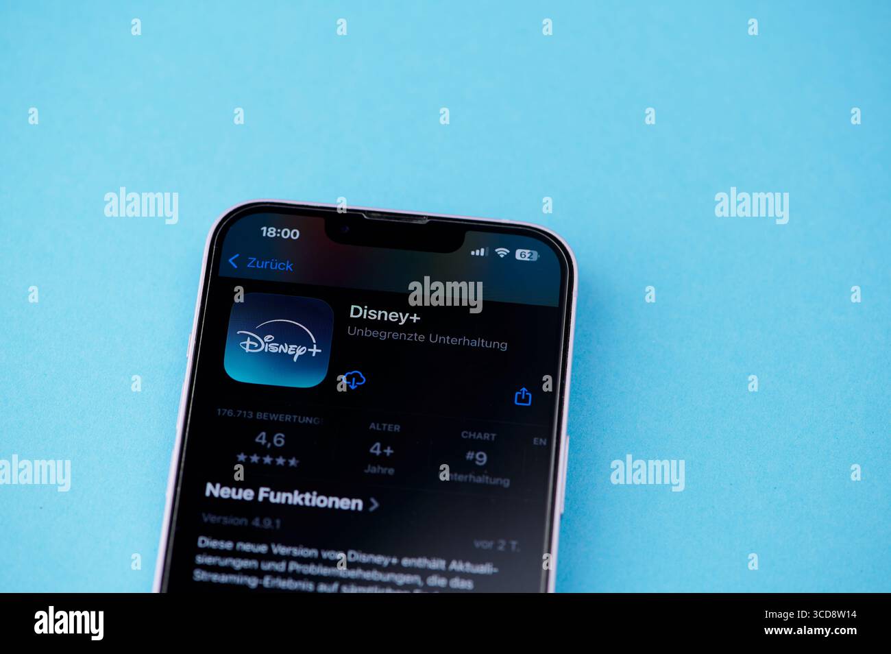 Mainz, Allemagne - 10 août 2025 : L'utilisateur navigue l'application Disney plus sur son smartphone sur fond bleu. Banque D'Images