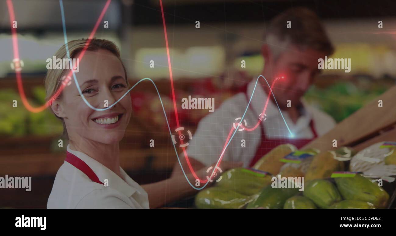 Travailleur souriant portant un tablier rouge triant les fruits et légumes dans l'allée des fruits et légumes avec superposition de graphiques, espace de copie Banque D'Images