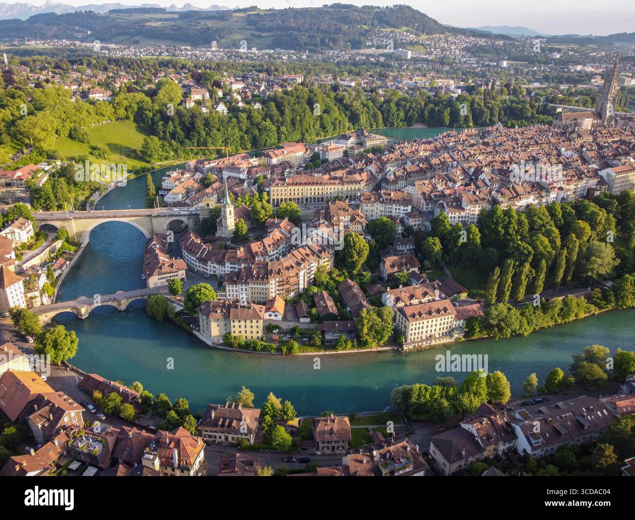 Vue aérienne de l'Aar qui courbe autour de la vieille ville avec ses toits de tuiles rouges distinctifs et l'imposant Bern Minster, Berne, Canton de Berne, Suisse. Banque D'Images