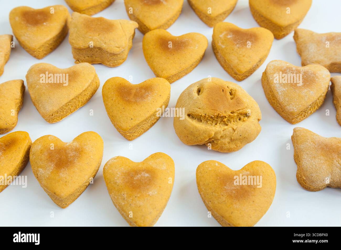 Biscuits faits maison sous forme de coeurs et de visage sur une plaque blanche. Banque D'Images