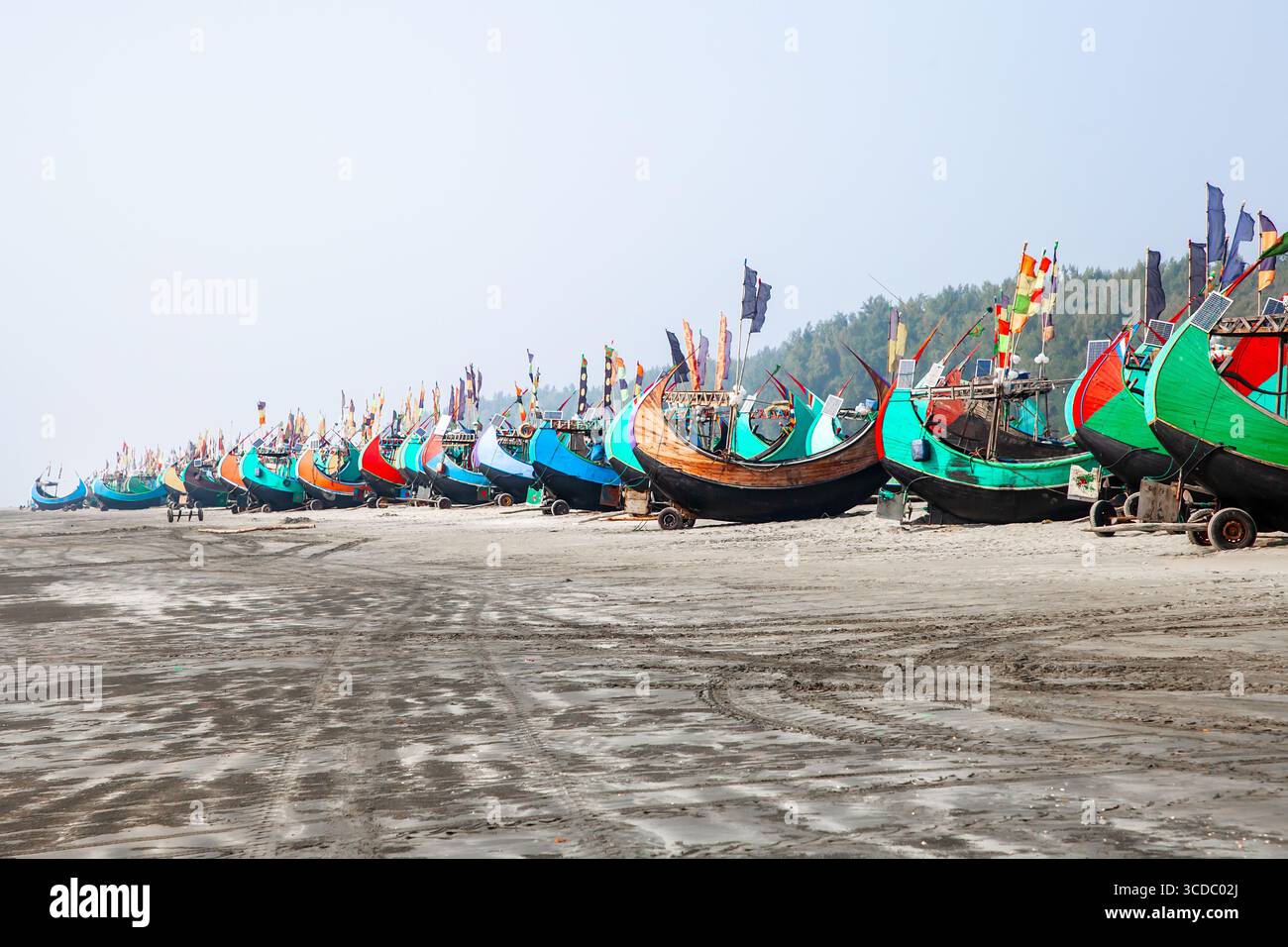 Cox's Bazar, Bangladesh - 06 février 2024 : vue sur les bateaux de pêche animés alignés soigneusement le long de la plage Cox's Bazar - Teknaf Highway, leurs coques colorées contrastant avec le sable sombre. Banque D'Images