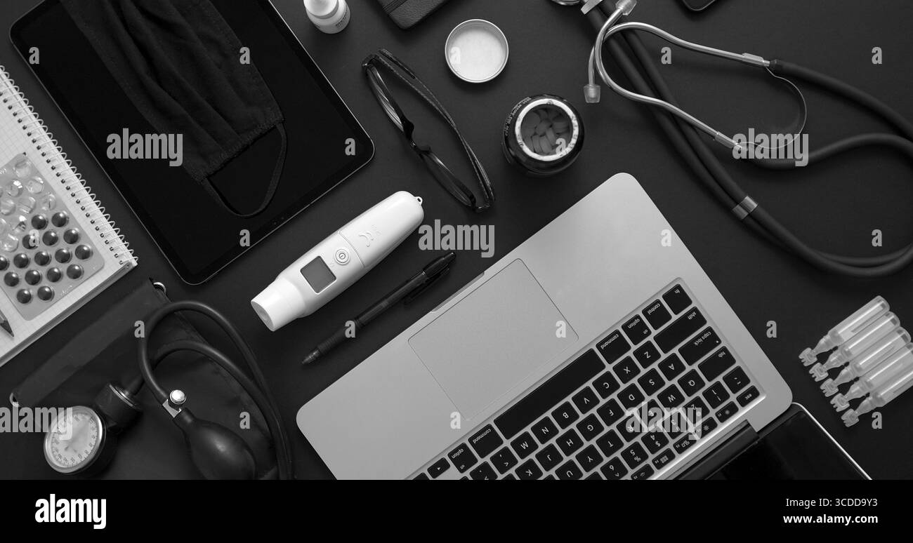 Concept de bureau pour médecin. Divers outils et accessoires médicaux placés sur une table noire comme maquette. Avec ordinateur portable, médecine, stéthoscope, pression Banque D'Images