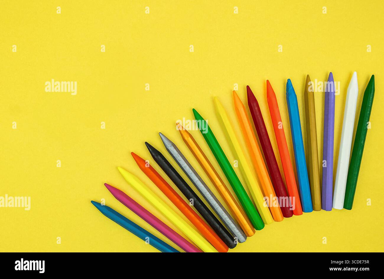 Vue de dessus de crayons colorés. Gros plan ensemble de crayons de couleur mélangée. Crayons de cire colorés isolés sur fond jaune. masque. Arrière-plan Banque D'Images