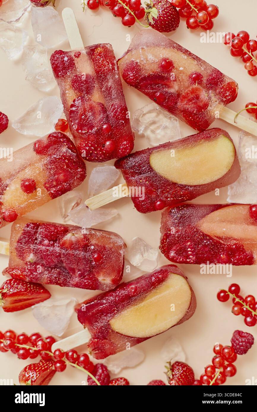 Maison congelée diverses baies rouges jus naturel popsicles - paletas - glace POPS. Vue de dessus, à plat, en hauteur. Concept de collation estivale saine Banque D'Images