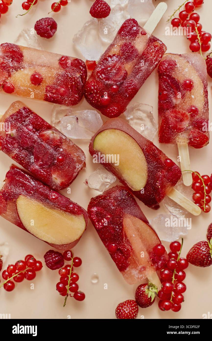 Maison congelée diverses baies rouges jus naturel popsicles - paletas - glace POPS. Vue de dessus, à plat, en hauteur. Concept de collation estivale saine Banque D'Images