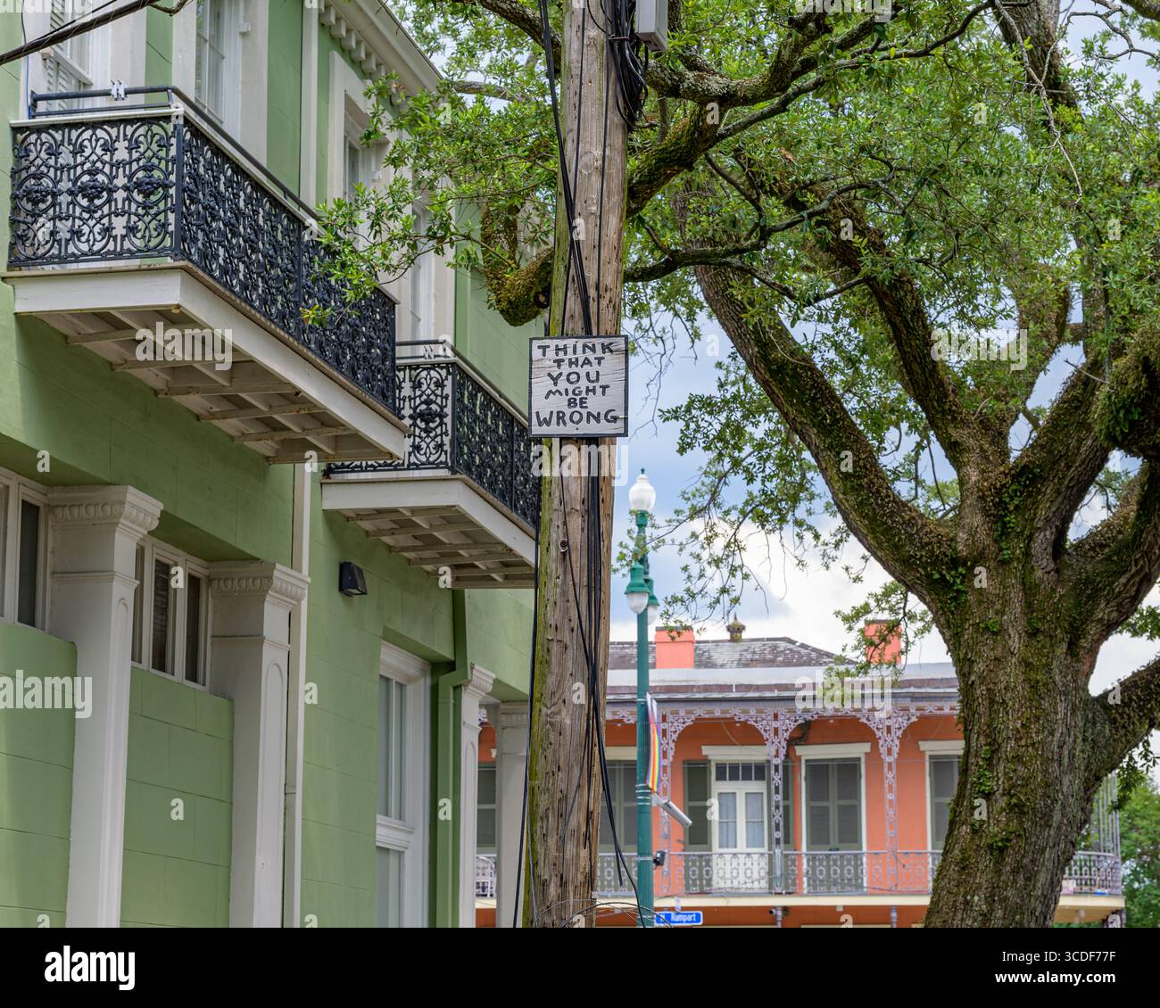 La Nouvelle-Orléans, LOUISIANE, États-Unis - 1er juin 2025 : bâtiments historiques sur les côtés opposés de Rampart Street dans les quartiers Treme et French Quarter et panneau sur un poteau de service public disant « pensez que vous pourriez avoir tort ». Banque D'Images