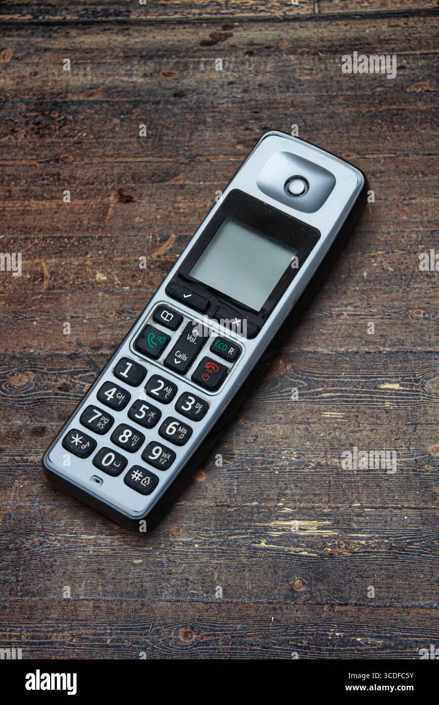 Image de nature morte d'un vieux combiné téléphonique fixe usé et mis au rebut sur un vieux plancher de bois usé Banque D'Images