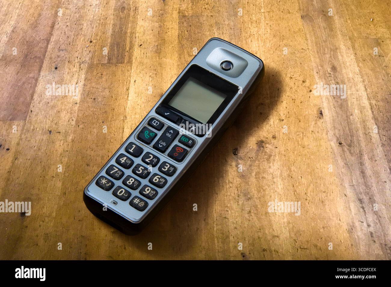 Image de nature morte d'un vieux combiné téléphonique fixe usé et mis au rebut sur un vieux plancher de bois usé Banque D'Images