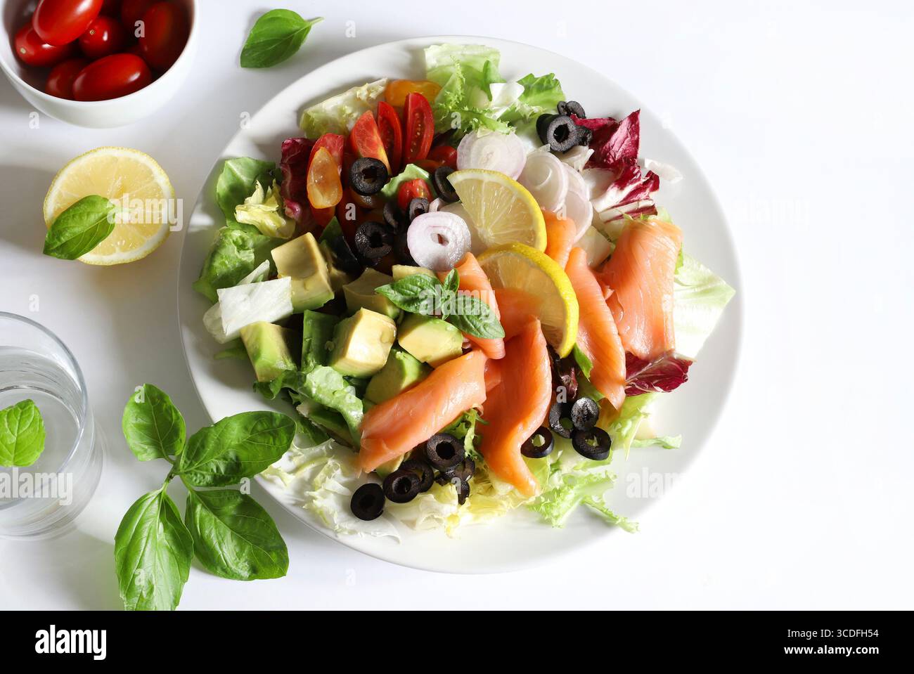 Salade avec saumon fumé, avocat, olives, citron, laitue et légumes frais sur une assiette blanche. Nourriture saine. Directement au-dessus. Banque D'Images