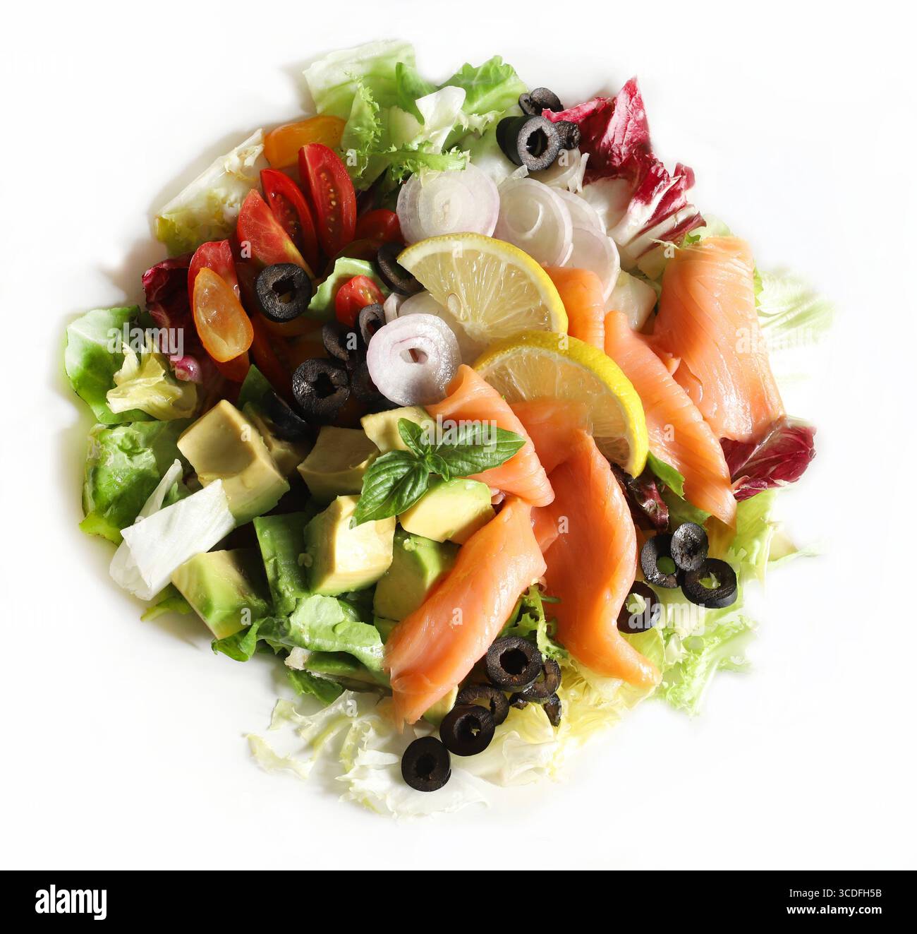 Salade avec saumon fumé, avocat, olives, citron, laitue et légumes frais sur une assiette blanche. Nourriture saine. Directement au-dessus. Banque D'Images