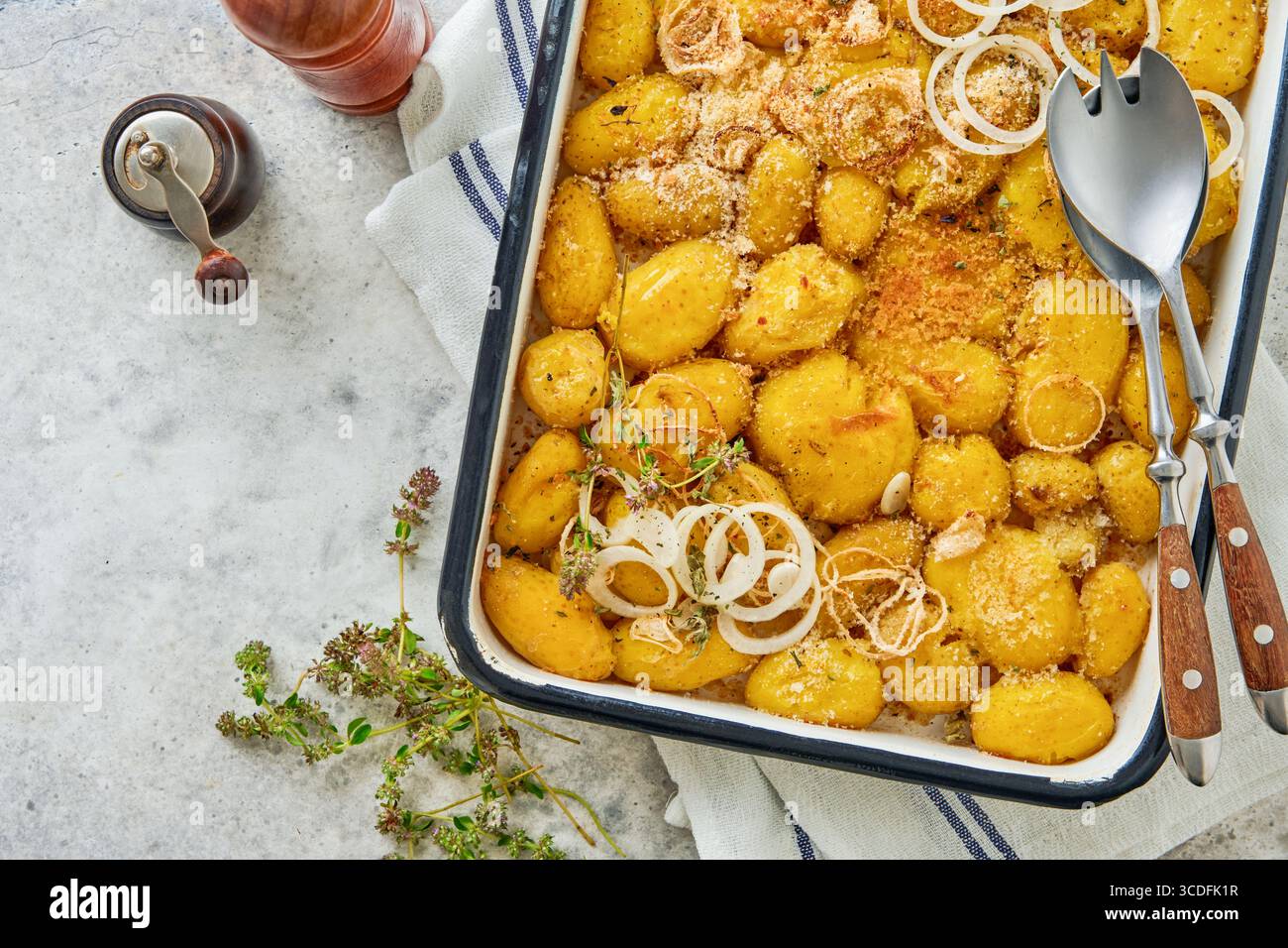 Pommes de terre écrasées rôties garnies d'herbes fraîches et d'oignons dans un plateau en émail rustique. Plat traditionnel anglais. Vue de dessus. Banque D'Images