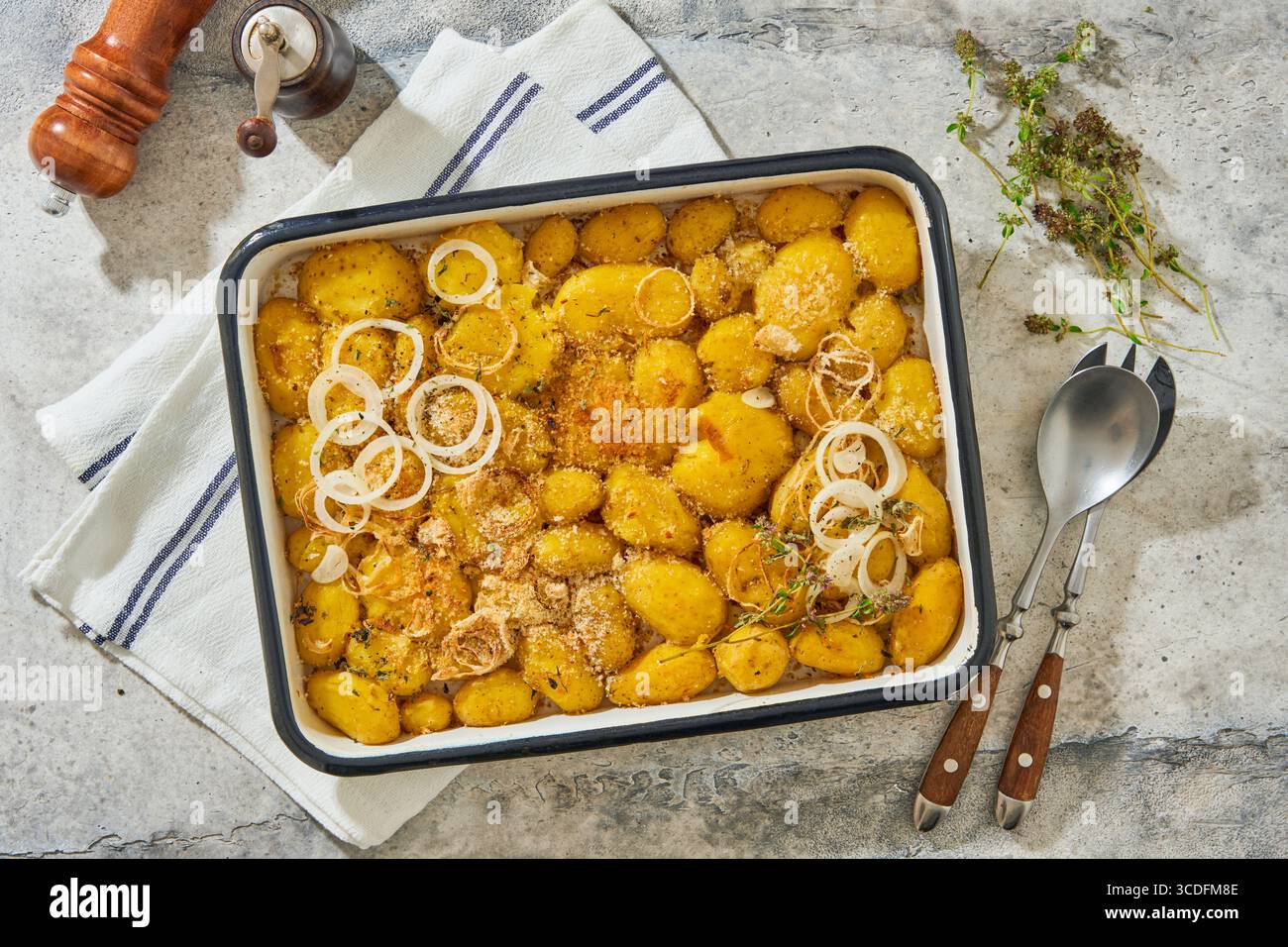Pommes de terre écrasées rôties garnies d'herbes fraîches et d'oignons dans un plateau en émail rustique. Plat traditionnel anglais. Vue de dessus. Banque D'Images