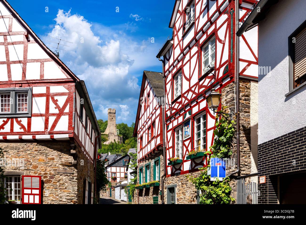 Ruelle historique dans Monreal bordée de maisons à colombages avec vue pittoresque sur les Philippsburg en arrière-plan Banque D'Images