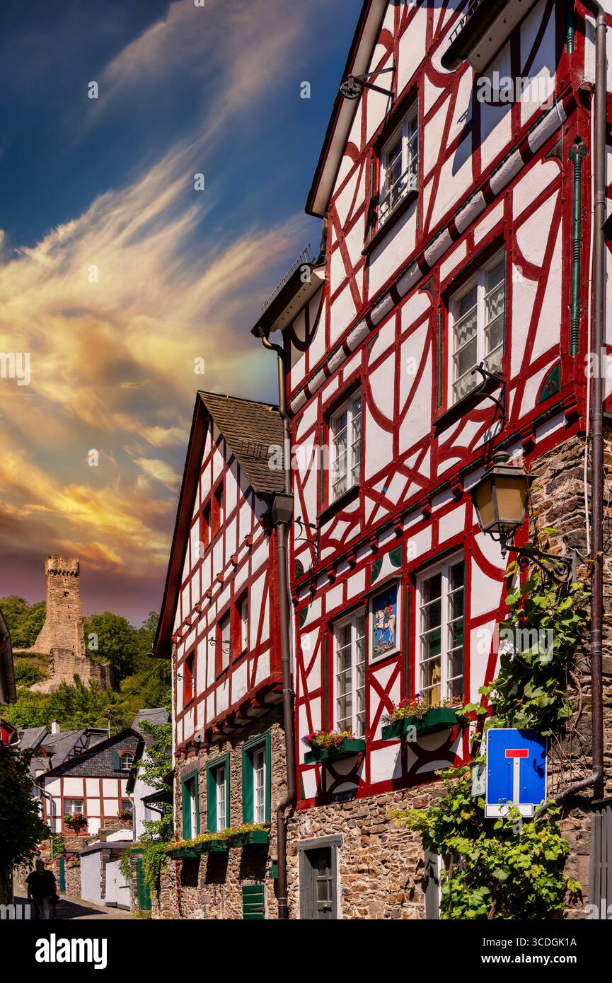 Monreal dans l'Eifel avec des maisons historiques à colombages et les Philippsburg dans la lumière chaude du coucher du soleil Banque D'Images