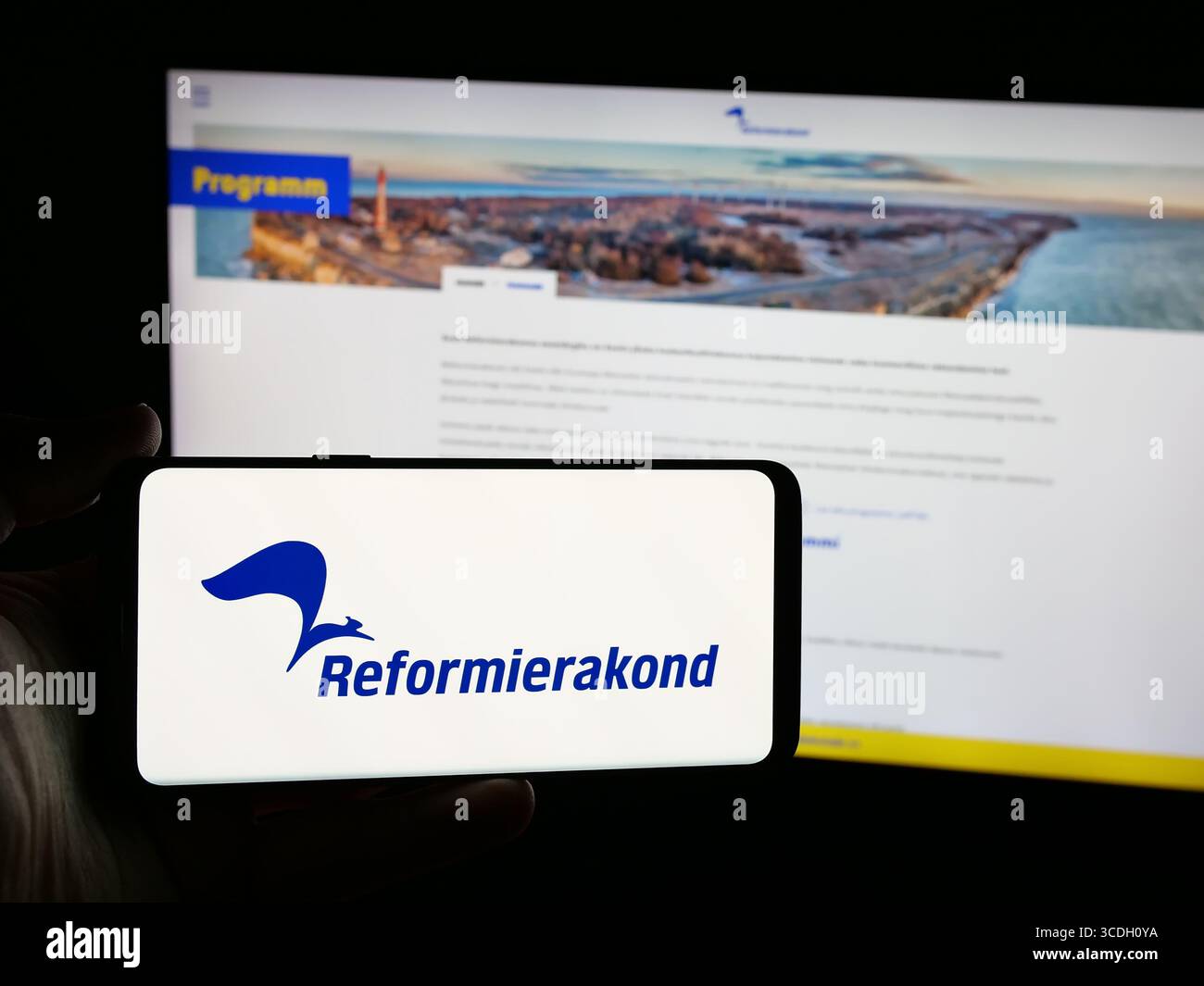 Stuttgart, Allemagne - 07‑25‑2025 : personne tenant un smartphone avec le logo du parti politique estonien Eesti Reformierakond sur l'écran devant le site web. Banque D'Images