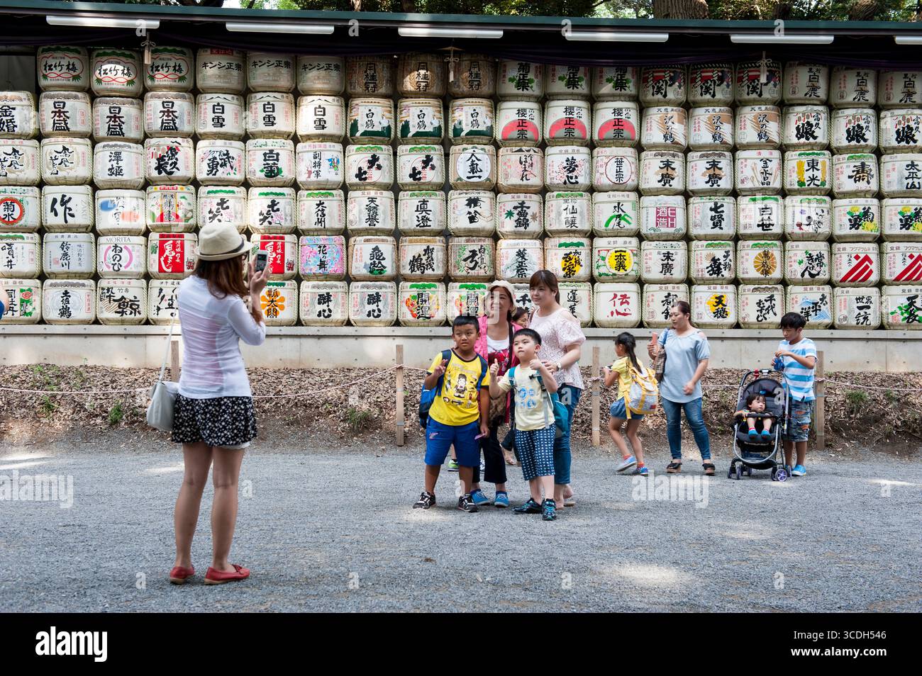 Les gens photographiant la famille avant les fûts de Sake enveloppés dans de la paille au sanctuaire Empereur Meiji Tokyo, officiellement Tokyo Metropolis, l'une des 47 préfectures Banque D'Images
