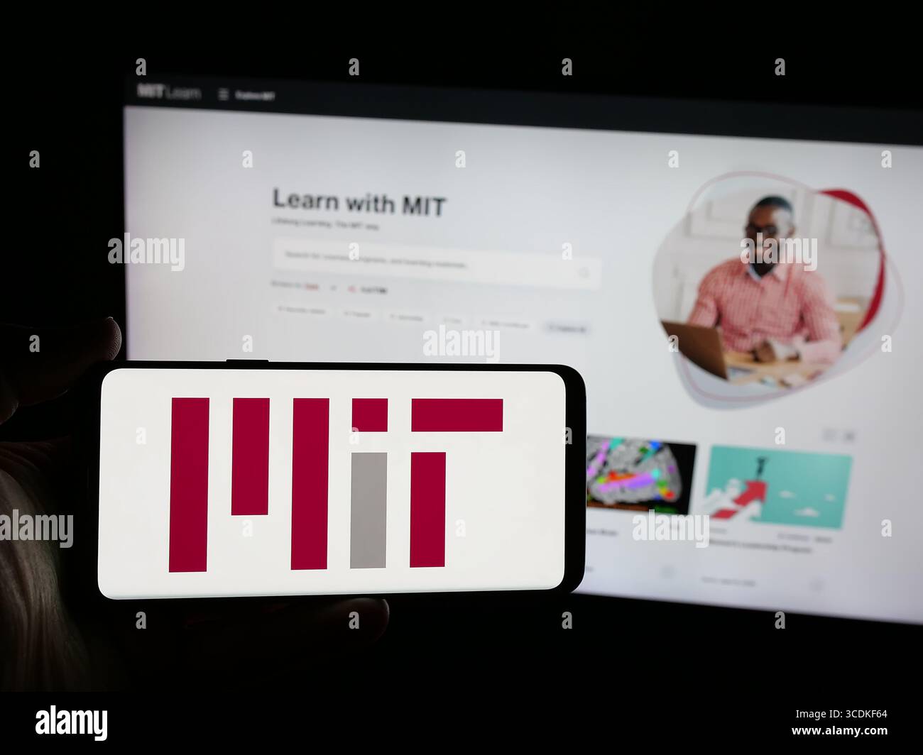 Stuttgart, Allemagne - 08-01-2025 : personne tenant un smartphone avec le logo du Massachusetts Institute of Technology (MIT) sur l'écran devant le site Web. Banque D'Images