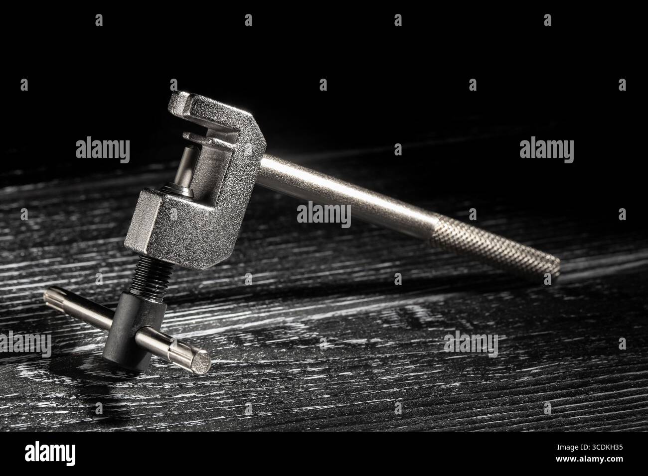 outil brise-chaîne de vélo sur fond de bois noir Banque D'Images