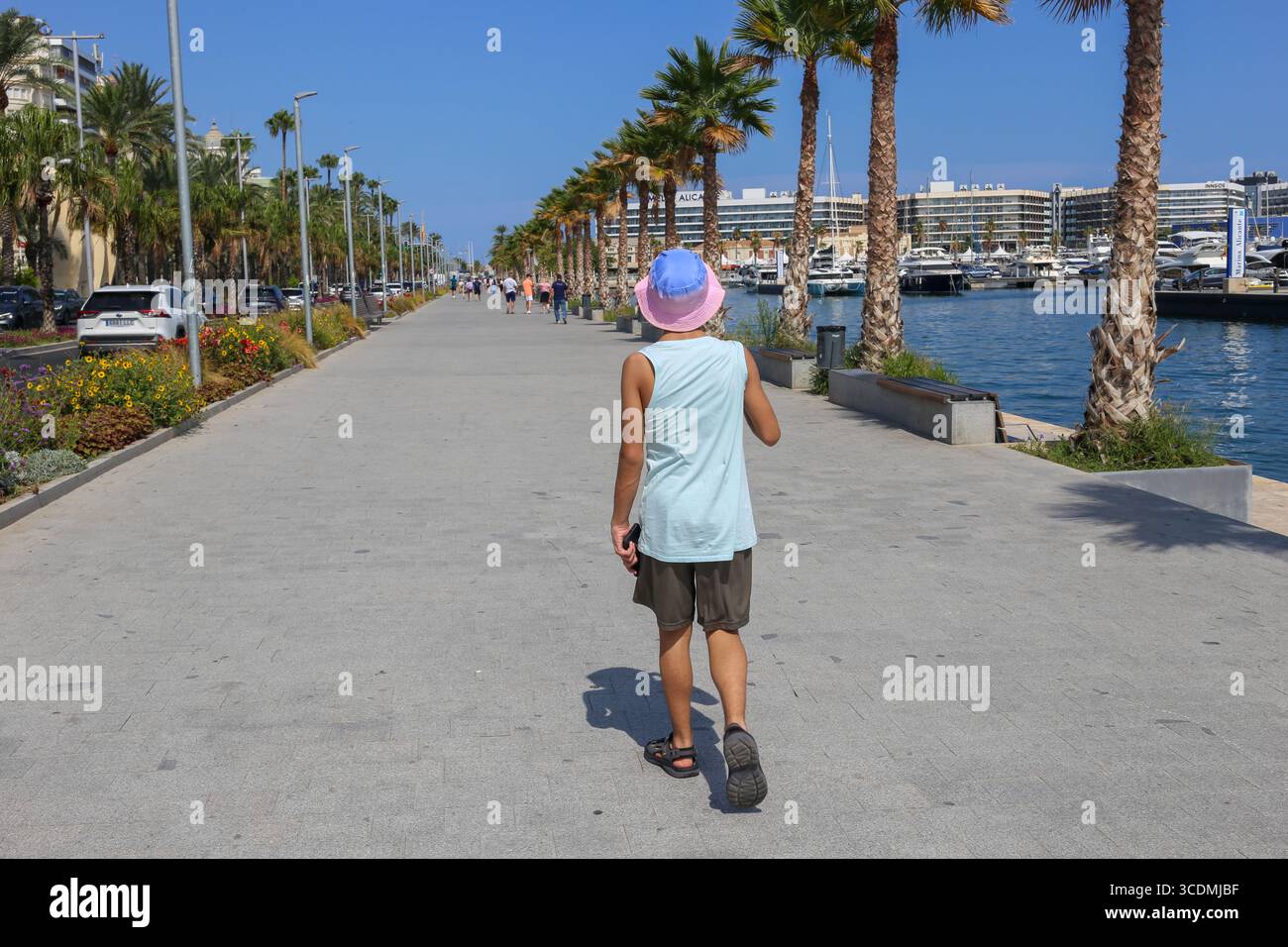 Alicante, Espagne, 13 août 2025 : un enfant marche le long de la promenade du front de mer d'Alicante pendant le tourisme à Alicante, à Alicante, Espagne, le 13 août 2025. Crédit : Alberto Brevers / Alamy Live News. Banque D'Images