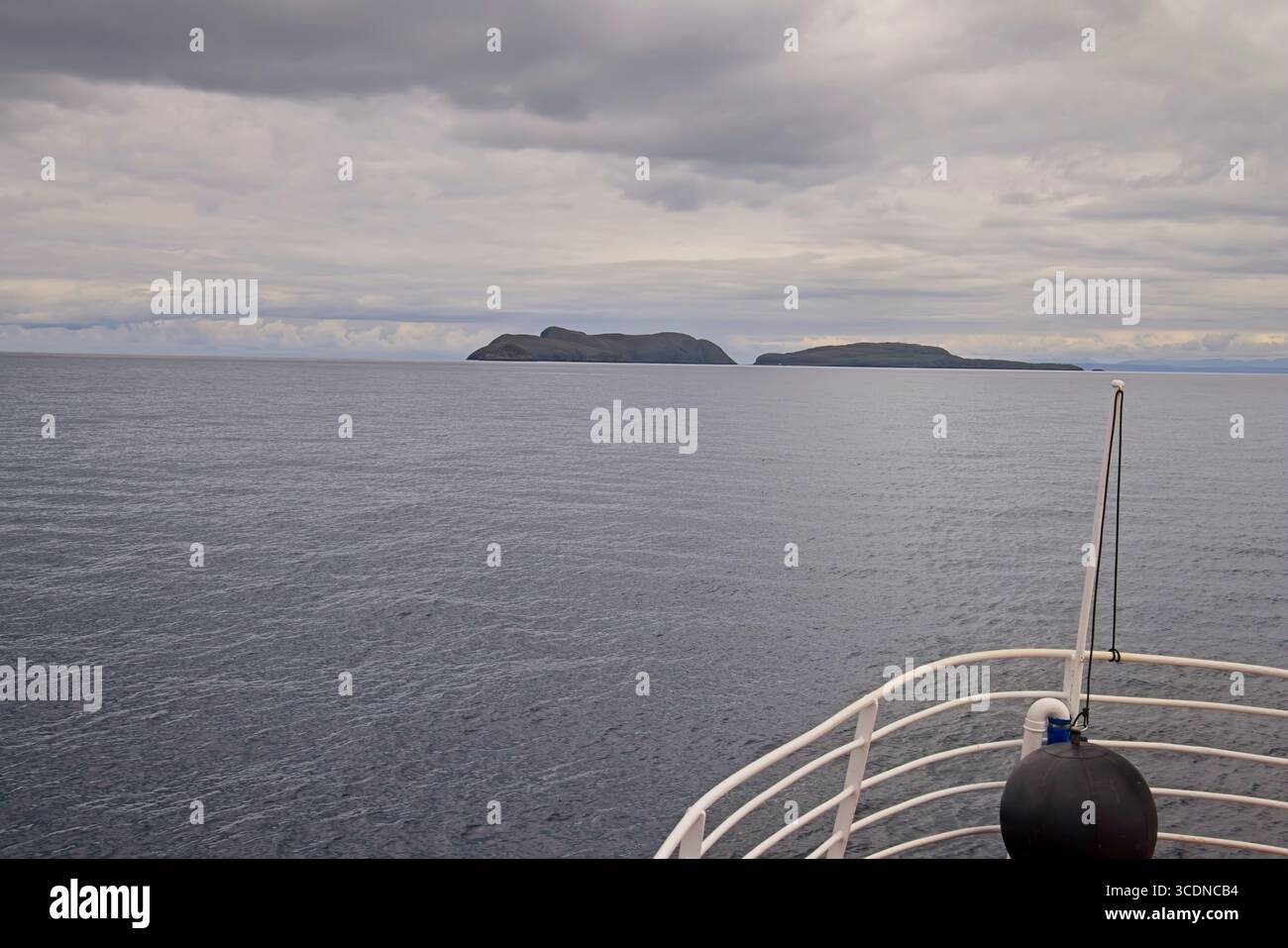 Approche des îles Shiant (Na h-Eileanan Shianta) en bateau depuis Harris, Hébrides extérieures, Écosse, avec ciel nuageux et mer calme. Banque D'Images