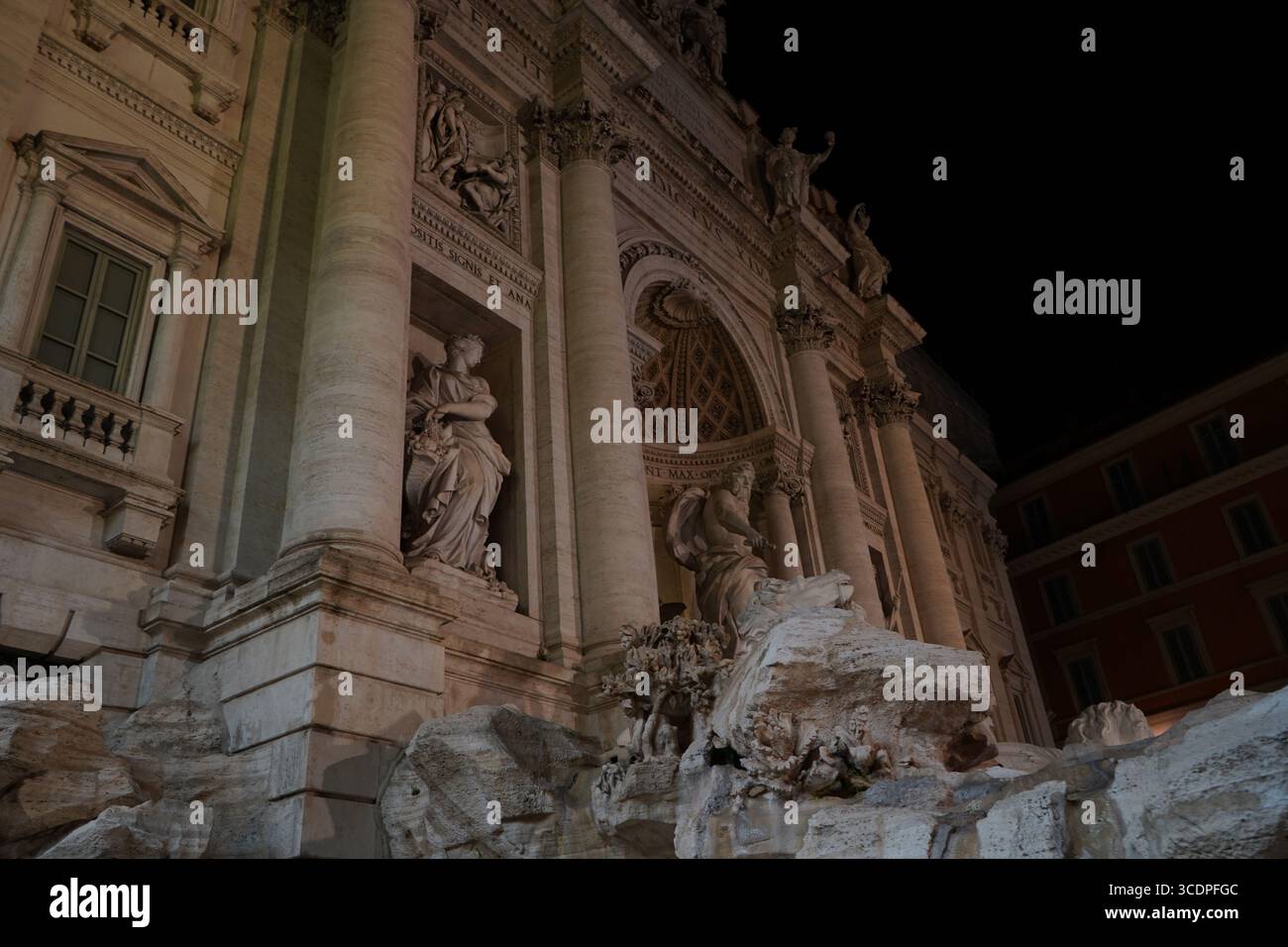Vue nocturne de l'emblématique fontaine de Trevi, mettant en valeur son architecture baroque époustouflante, ses statues de marbre et son éclairage spectaculaire. Banque D'Images