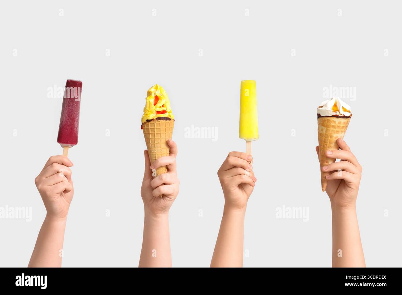 Mains féminines avec différentes glaces sucrées sur fond gris Banque D'Images