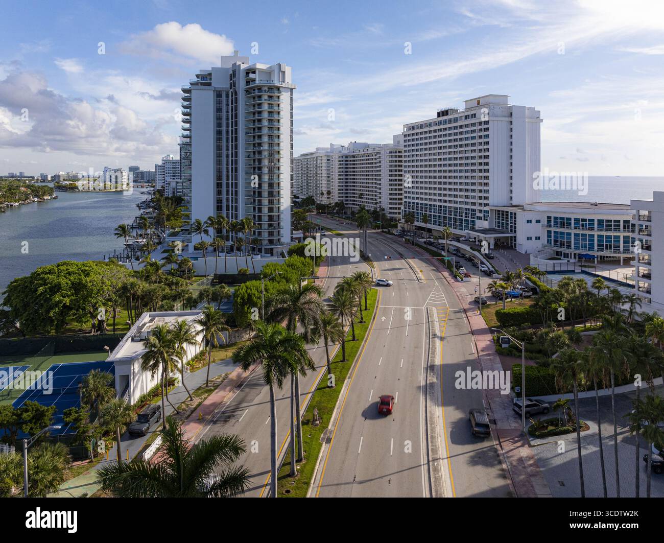 Vue aérienne de Collins Avenue bordée de palmiers et de bâtiments modernes contrastant avec l'océan bleu, Miami Beach, Floride, États-Unis. Banque D'Images