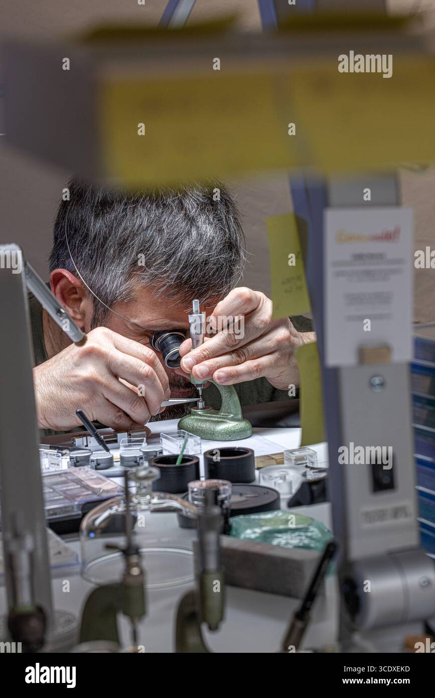 Gros plan d’un horloger travaillant chez Urwerk avec des composants délicats à Genève, Suisse. Banque D'Images