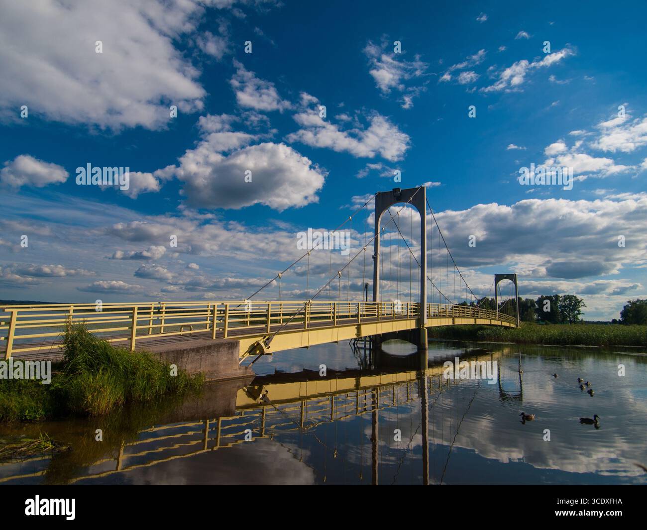 Juillet 2010, Võru, Estonie : Pont Roosisaare jaune sur le lac Tamula sous un ciel bleu d'été avec des nuages. Banque D'Images