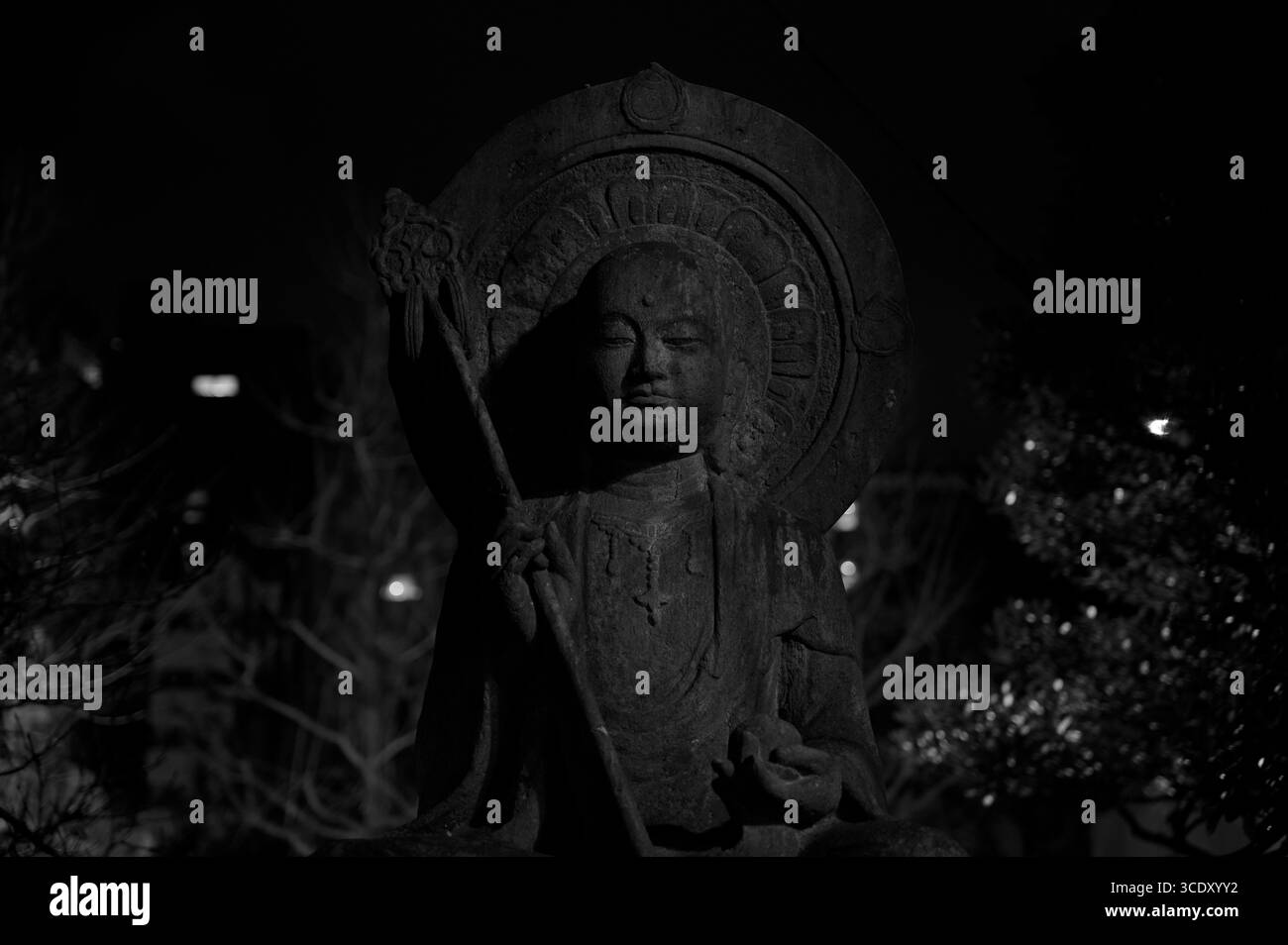 B&w photo d'une statue en pierre d'une divinité bouddhiste la nuit dans le temple Sensō-ji Banque D'Images