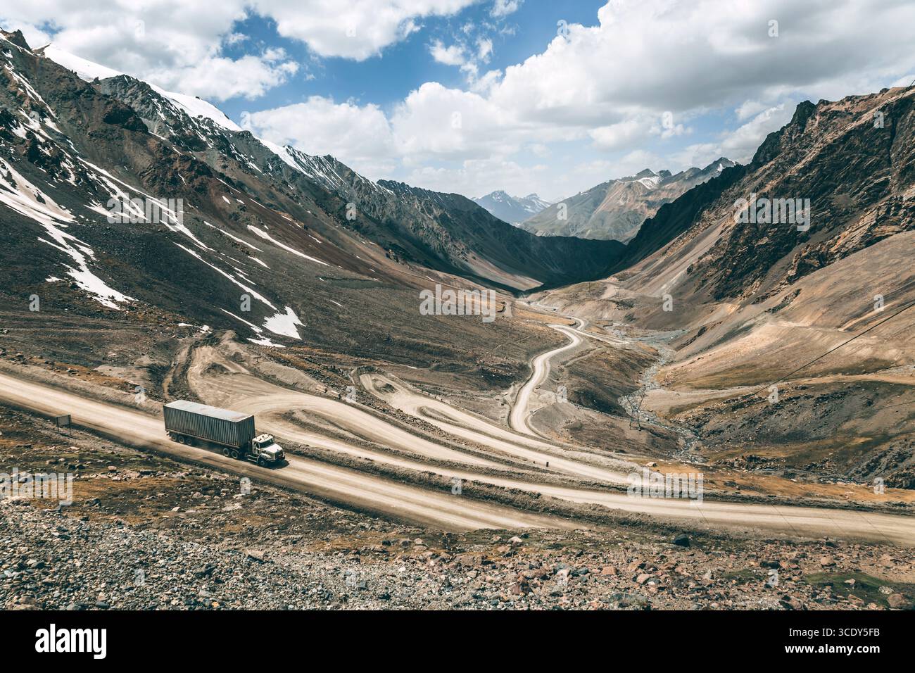 Un camion descend le long d'une route sinueuse à partir d'un col de montagne. livraison de marchandises dans des zones difficiles d'accès. Banque D'Images